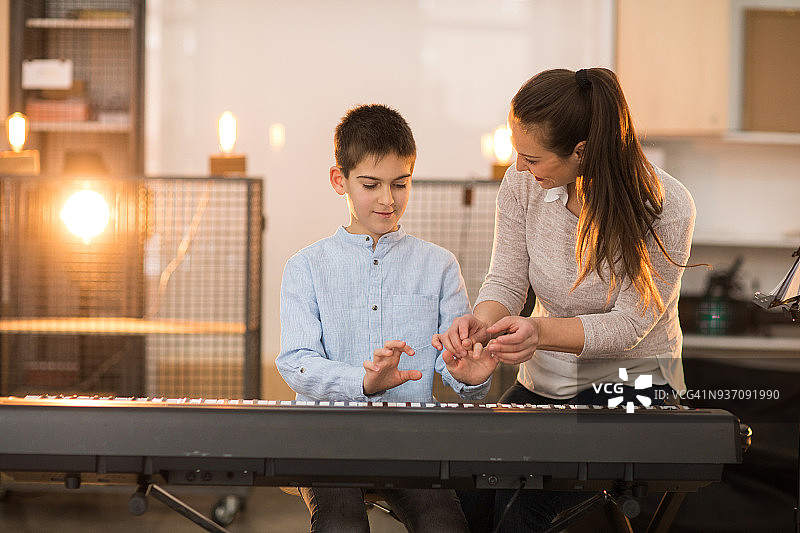 男孩学习弹钢琴图片素材