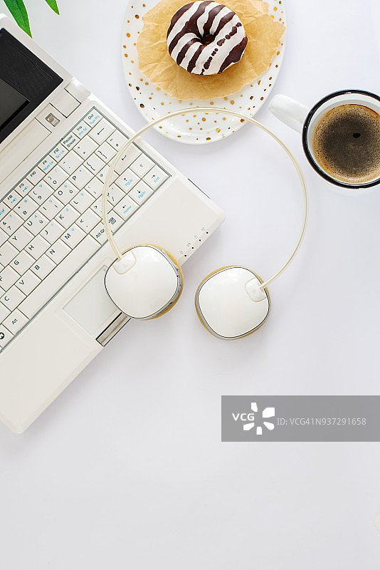 桌面视角：空白记事本、打开的笔记本电脑、咖啡和甜甜圈图片素材
