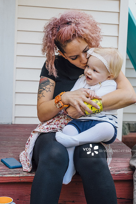 女人在自家房屋的门廊上和婴儿玩耍图片素材
