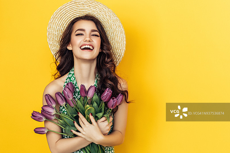 手捧紫色郁金香的迷人女性图片素材