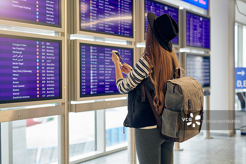 年轻女人在机场查看航班时刻表图片素材