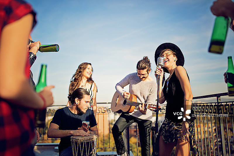 朋友们在屋顶露台上举办音乐会庆祝图片素材