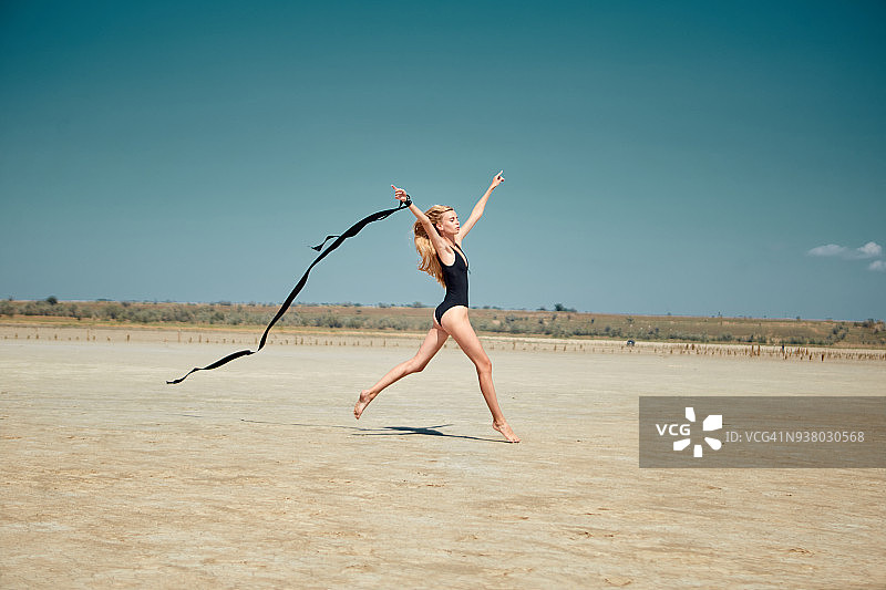 在沙漠中跳舞的年轻女人图片素材