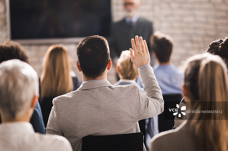 商务人士在会议室研讨会上举手的背影图片素材