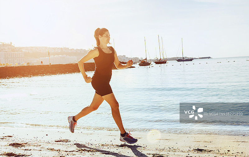 阳光下在沙滩上参加耐力赛的女人图片素材