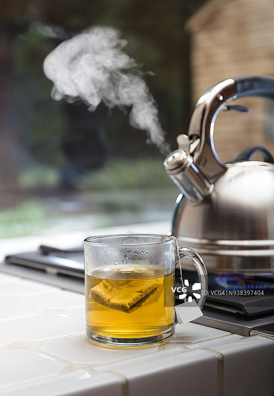 带蒸汽、茶杯和茶包的茶壶图片素材