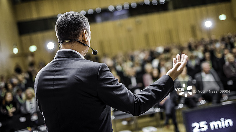商人在座无虚席的会议厅里演讲图片素材