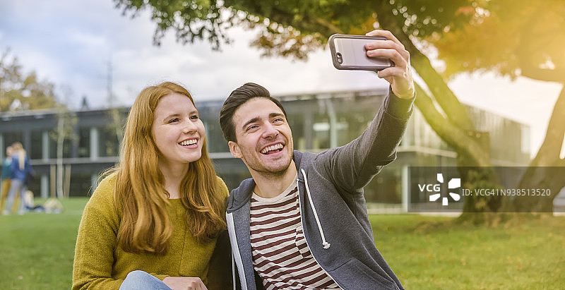 学生们在大学校园里用手机自拍图片素材