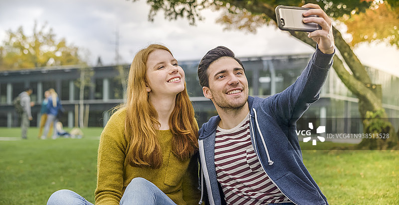 学生们在大学校园里用手机自拍图片素材