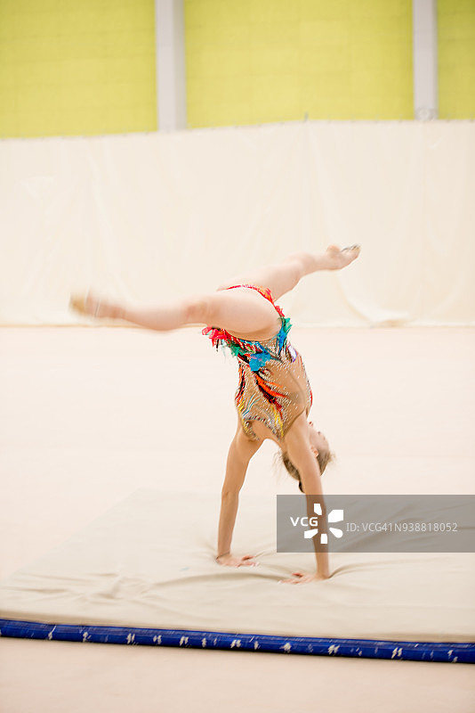 手倒立用腿接球的年轻艺术体操运动员图片素材