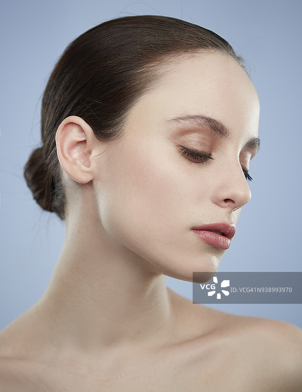 闭着眼睛的蓝眼睛棕发女子自然美妆侧面照图片素材