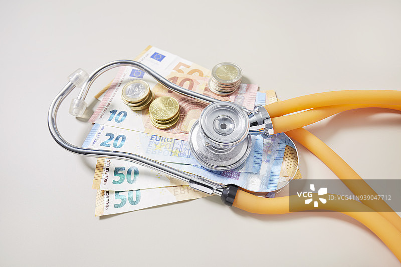 欧元纸币、硬币和听诊器俯视角度照片图片素材