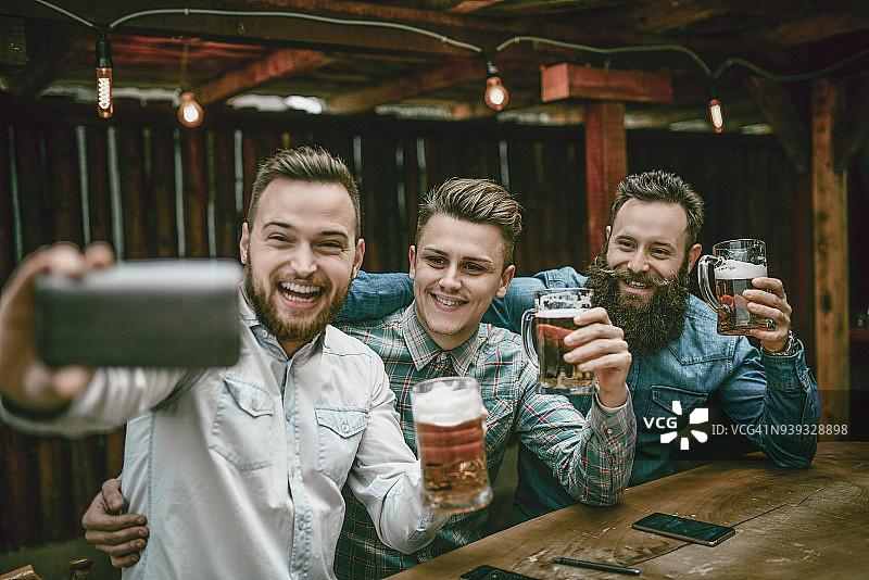 疯狂男人酒吧喝啤酒拍自拍图片素材