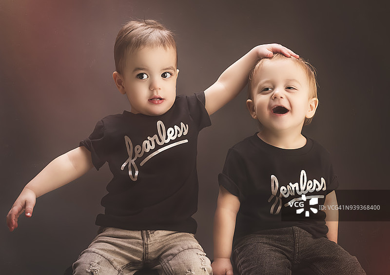 异卵双胞胎幼儿在工作室里互相玩耍和大笑图片素材