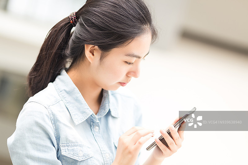 操作手机的年轻女孩图片素材