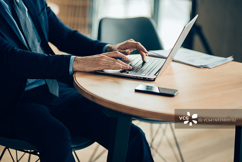 商人双手在笔记本电脑上打字图片素材