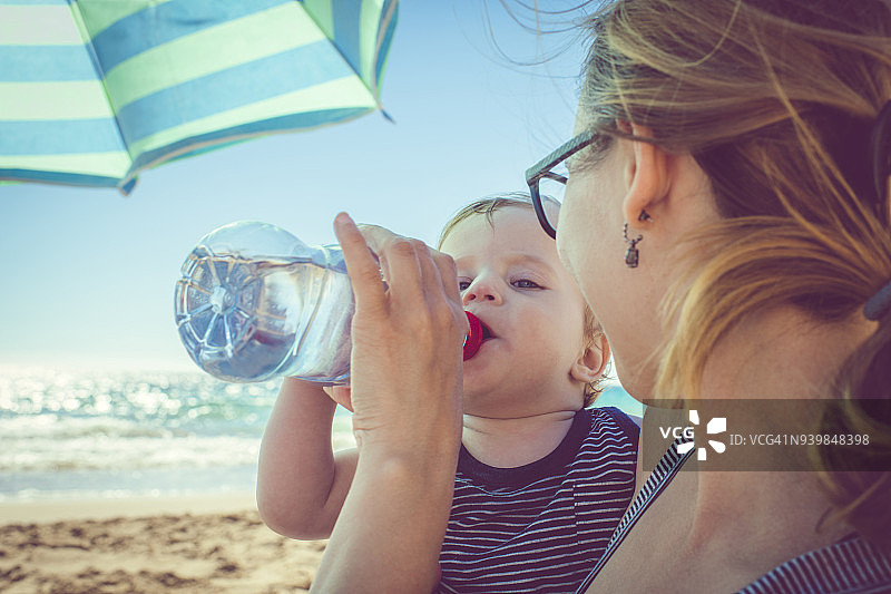 儿童在海滩上喝水图片素材