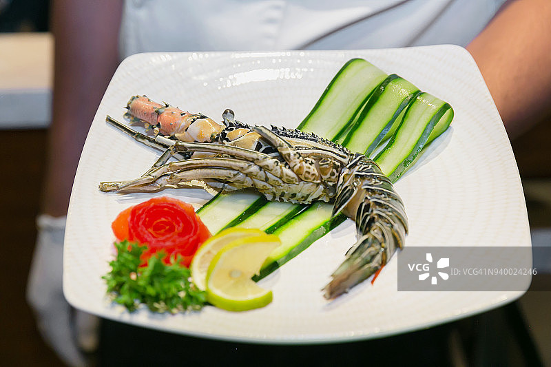 厨师展示盘中的新鲜龙虾图片素材