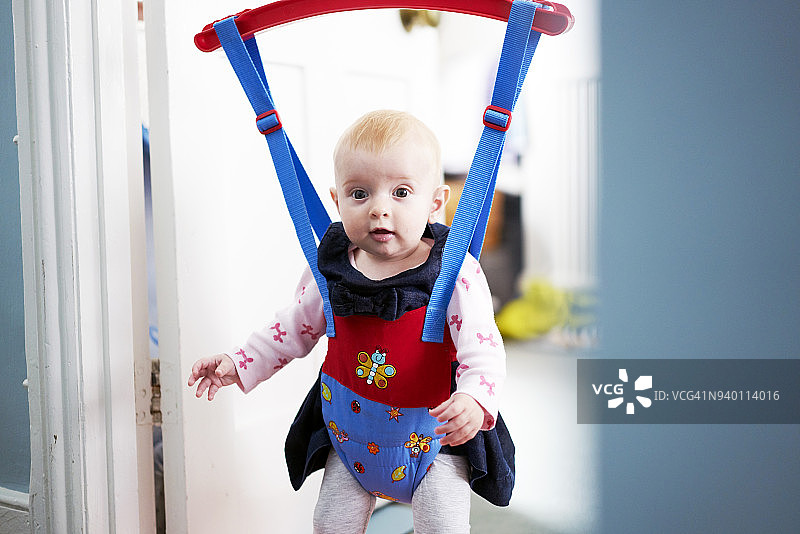 宝宝在家里的门上蹦蹦跳跳地看着镜头图片素材