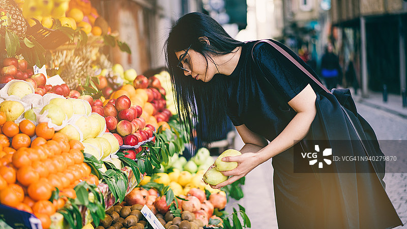 女人在街头市场购买水果图片素材