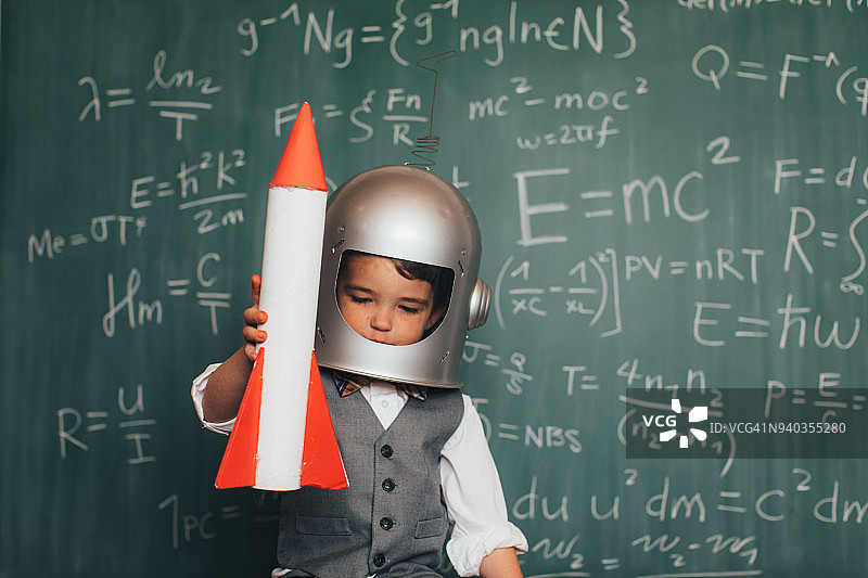 戴着太空头盔和火箭的年轻商务男孩图片素材