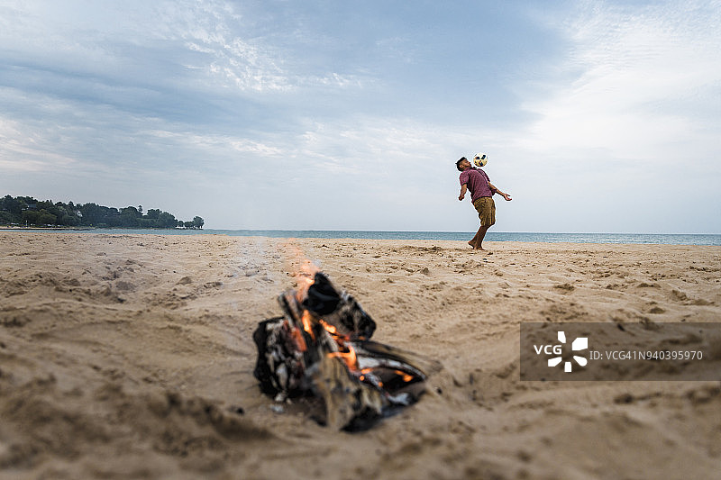 在美国威斯康星州希博伊根海滩上踢足球的西班牙裔青少年图片素材