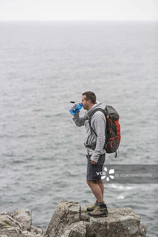 徒步者站在美国缅因州阿卡迪亚国家公园海边的岩石上图片素材