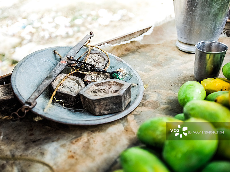 户外市场摊位上手秤的生锈砝码特写图片素材