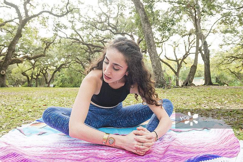 在迈阿密户外做束角式瑜伽的千禧一代女性图片素材