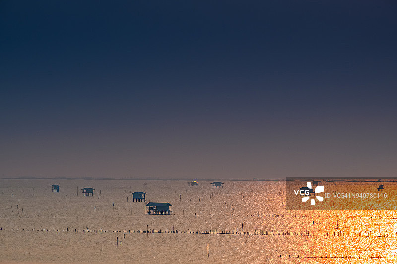 水上村庄和日落时分的牡蛎养殖场图片素材