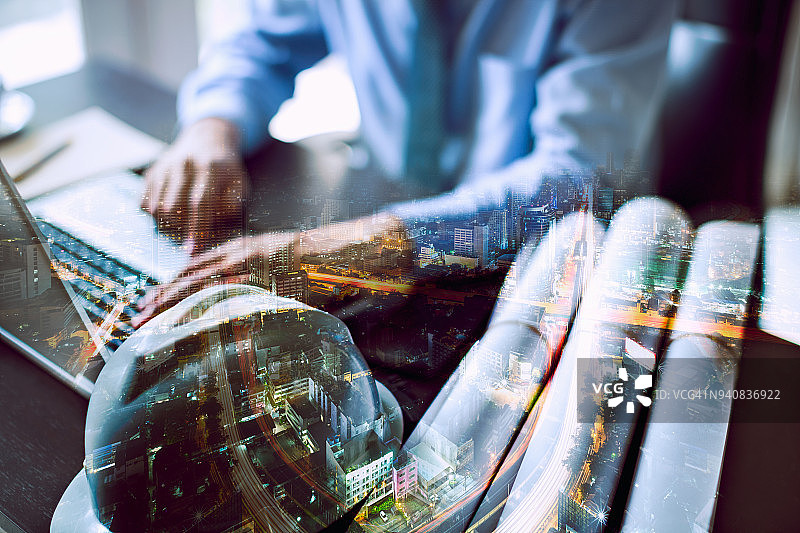 城市与商务人士使用电脑笔记本的双重曝光，作为业务发展概念图片素材