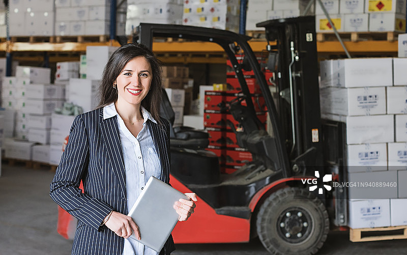 使用平板电脑的仓库女经理肖像图片素材