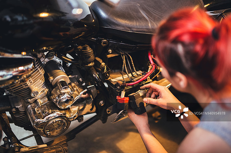 红发女孩修理摩托车图片素材