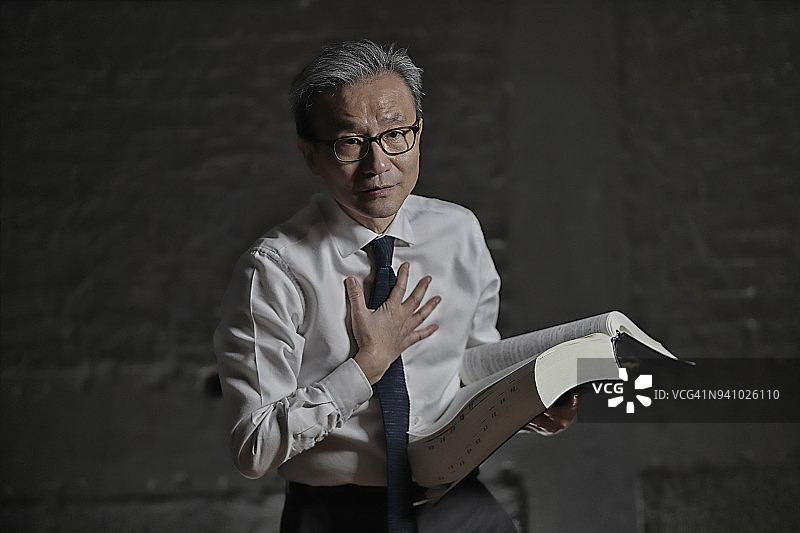 胸前放着法律书籍的律师的手图片素材