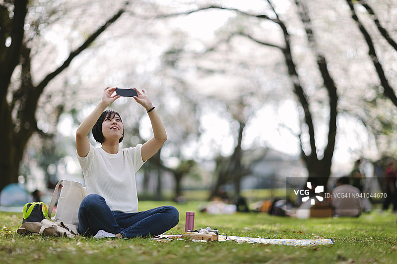 野餐时拍照的日本女人图片素材