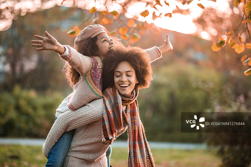 快乐的黑人母亲和女儿在秋日里玩耍图片素材