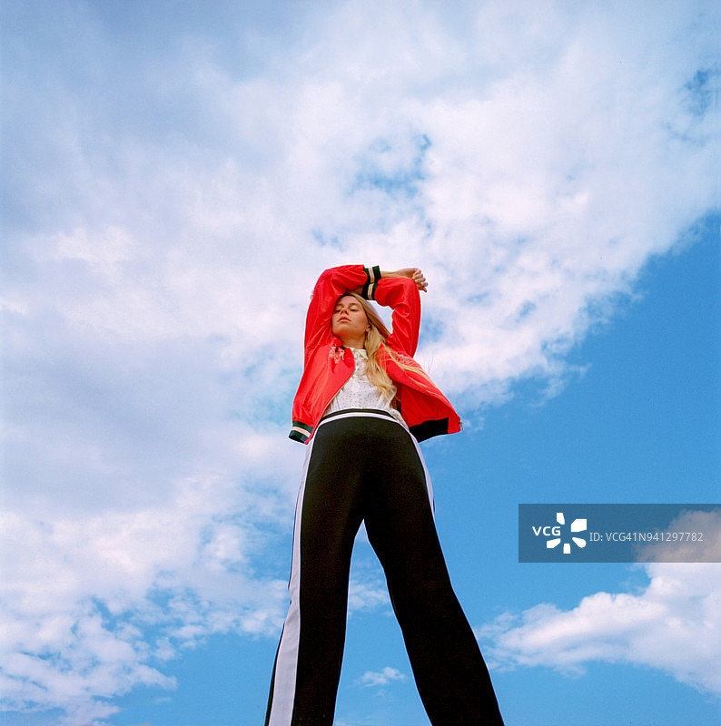 在蓝色天空下的美丽年轻女子肖像图片素材