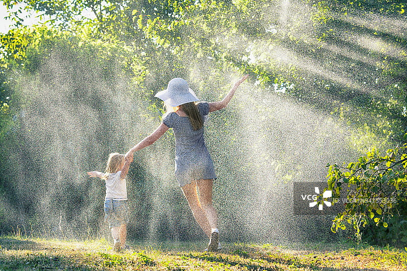 母亲和孩子在雨中玩耍图片素材