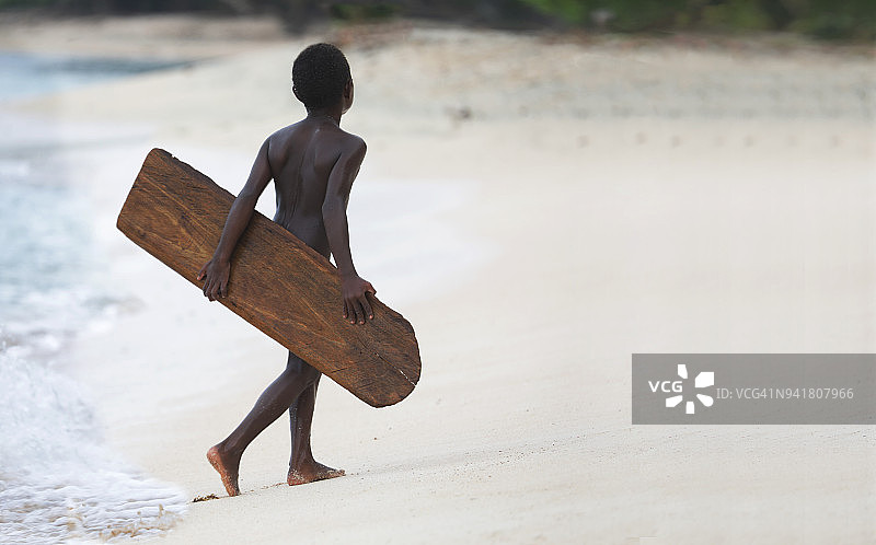 拿着木制冲浪板的太平洋岛屿儿童图片素材