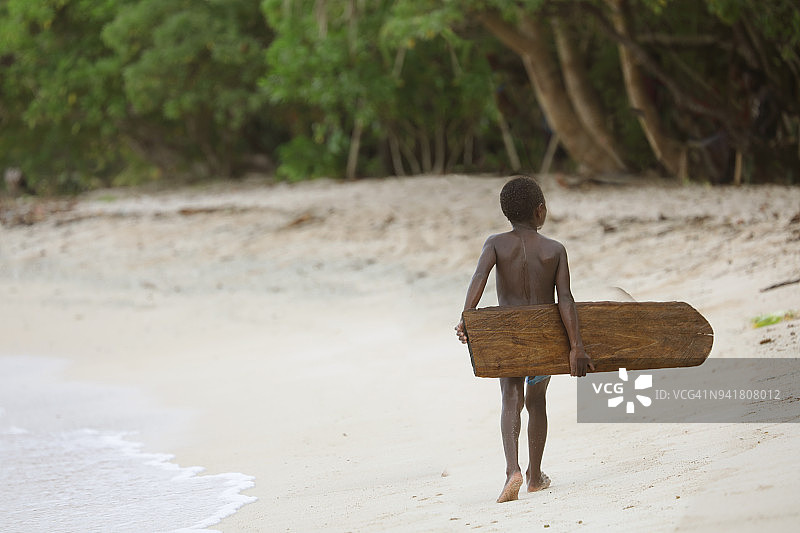 拿着木制冲浪板的太平洋岛屿儿童图片素材