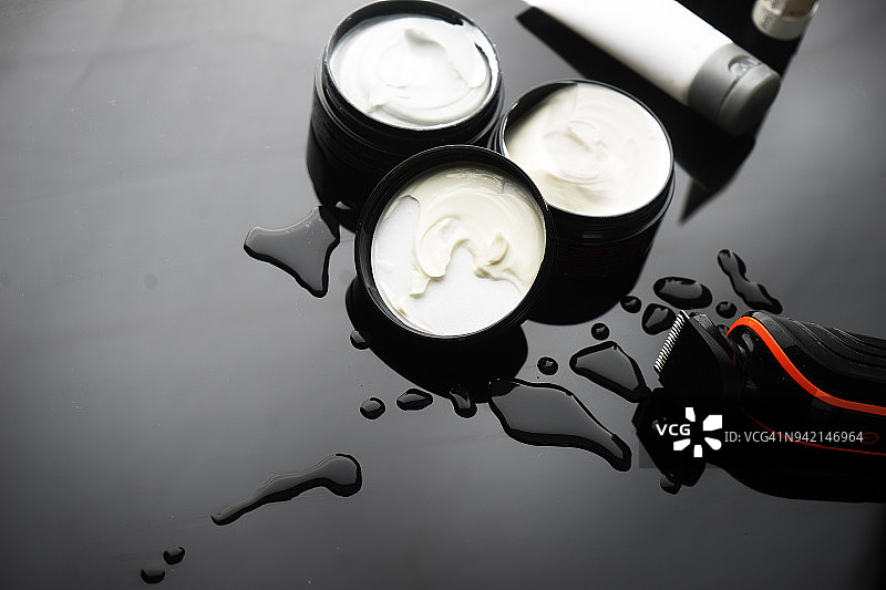 湿背景上的电子剃须和须后膏图片素材