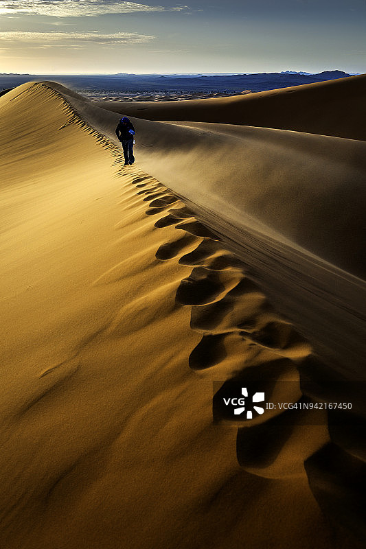 在摩洛哥Erg Chebbi沙丘欣赏日出的男人图片素材