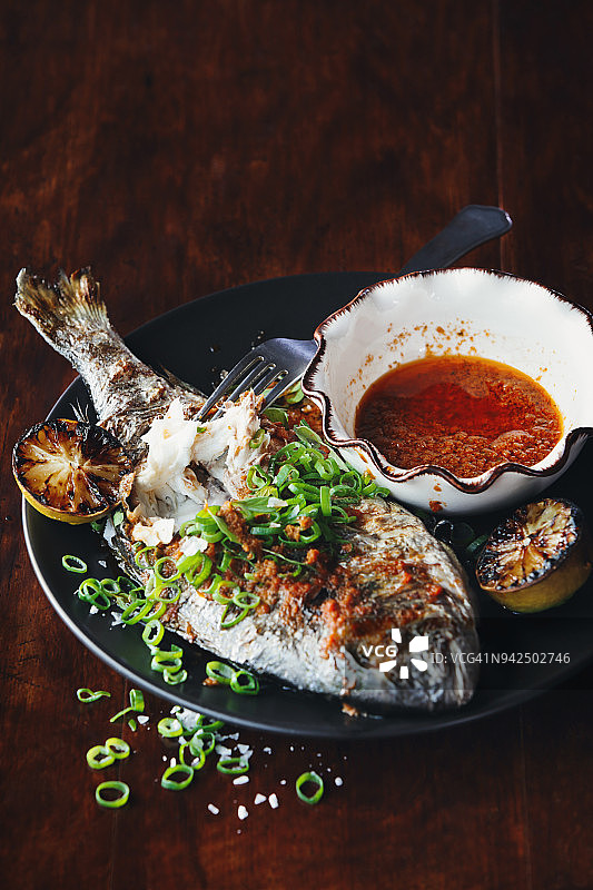 烤制整条鲷鱼配酱汁图片素材