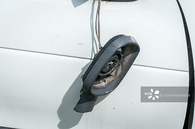 车门上损坏的后视镜，塑料框架由电线固定，没有玻璃图片素材