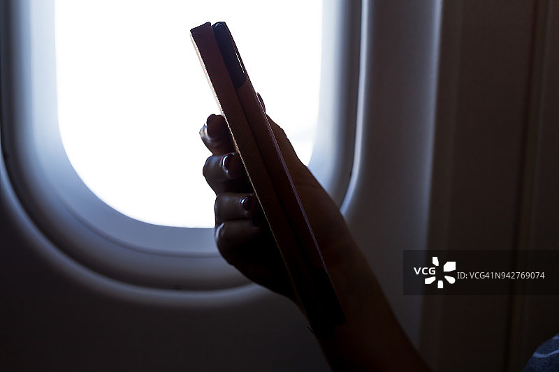 在飞机上阅读平板电脑图片素材