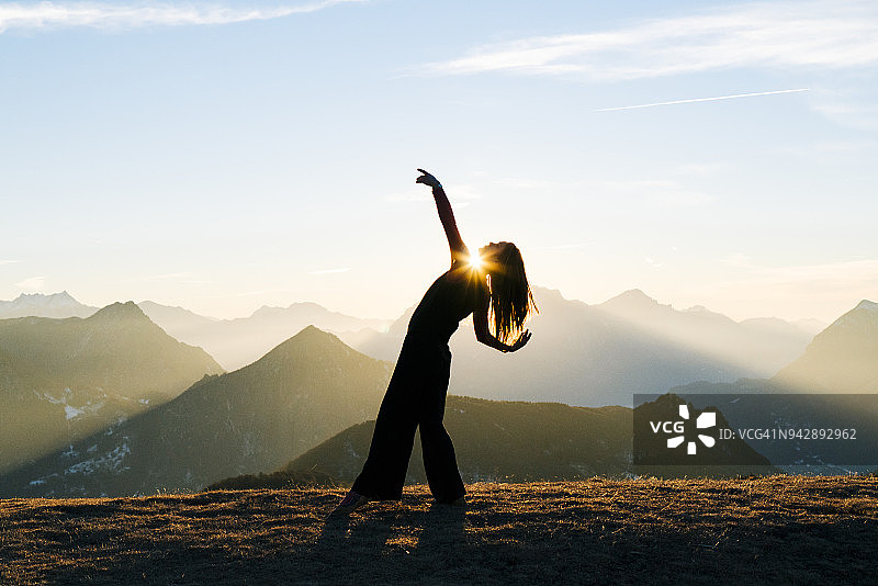 女人在山里日出时跳舞图片素材