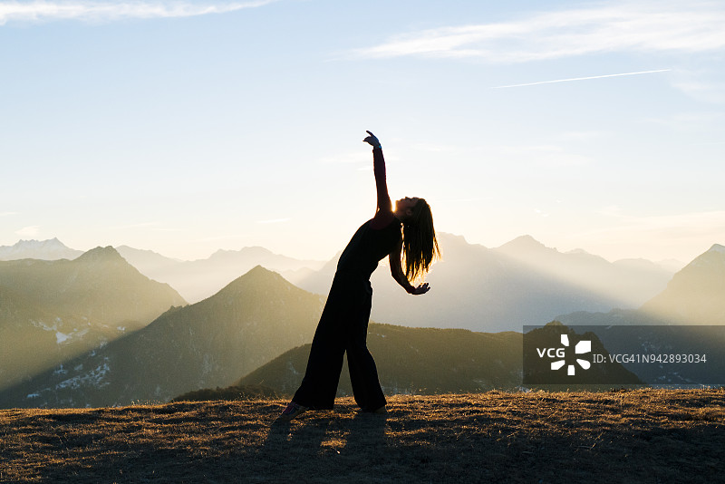 女人在山里日出时跳舞图片素材