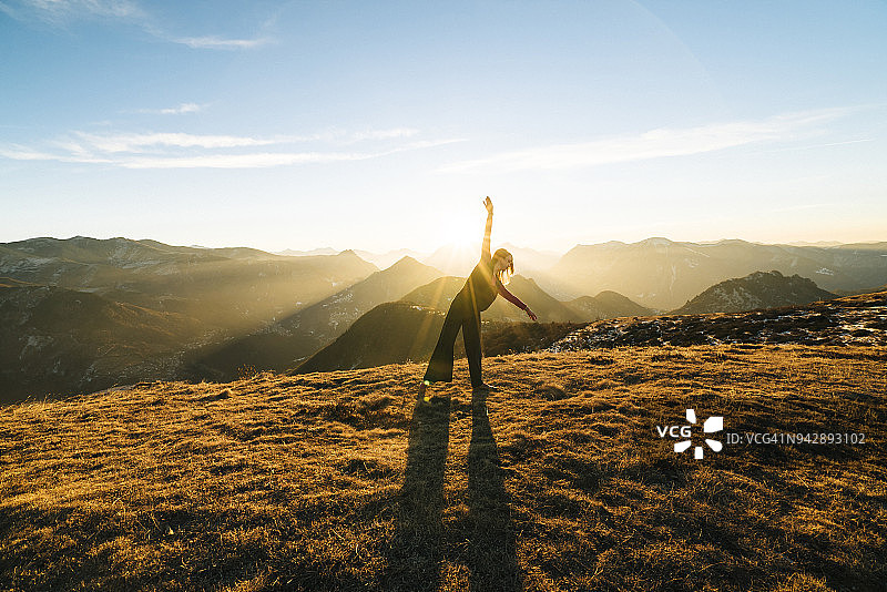 女人在山里日出时跳舞图片素材