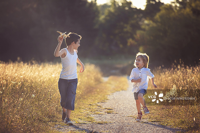 快乐的孩子们玩木制玩具飞机图片素材