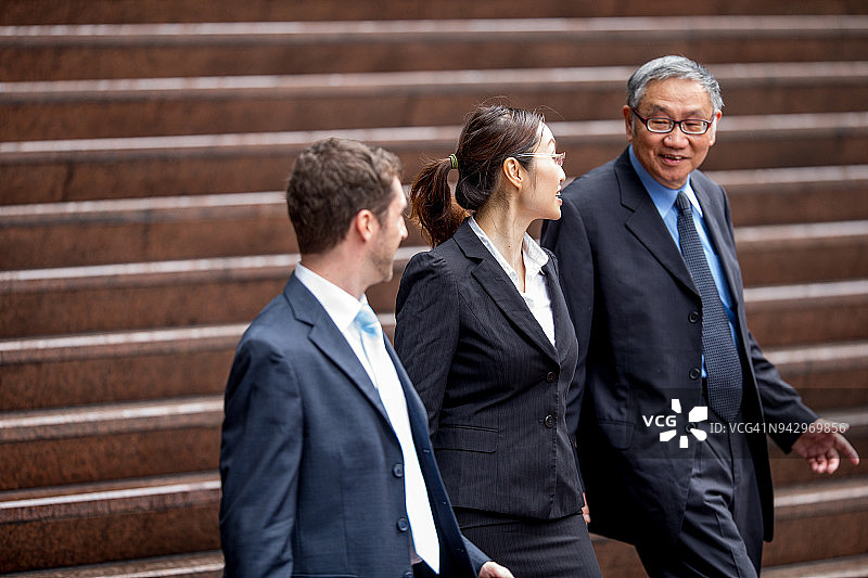 与翻译讨论与亚洲资深商人交易的白人商人图片素材